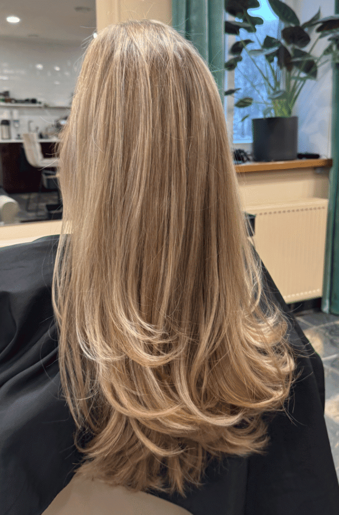 Sievietes mati ar skaistiem viļņiem un matu griezumu salonā.